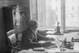 mies kirjoituspöydän ääressä